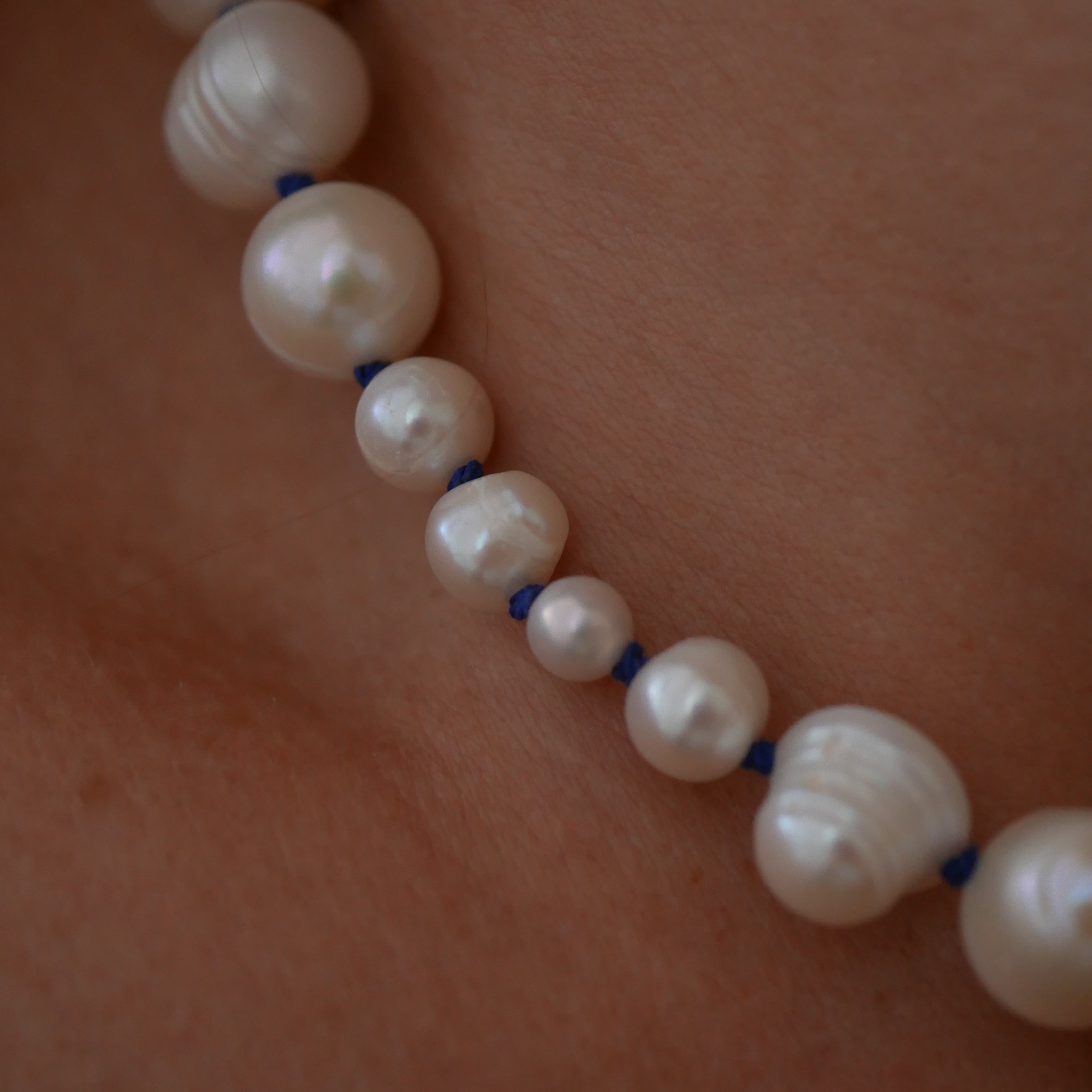 Pearl necklace on a person's neck with a close-up view
