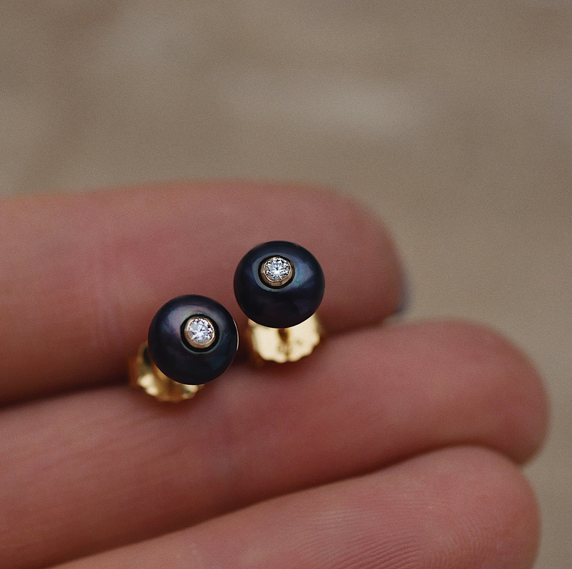 Fiona Dark Stud Earrings in hands