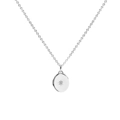 Silver necklace with a round pendant on a white background